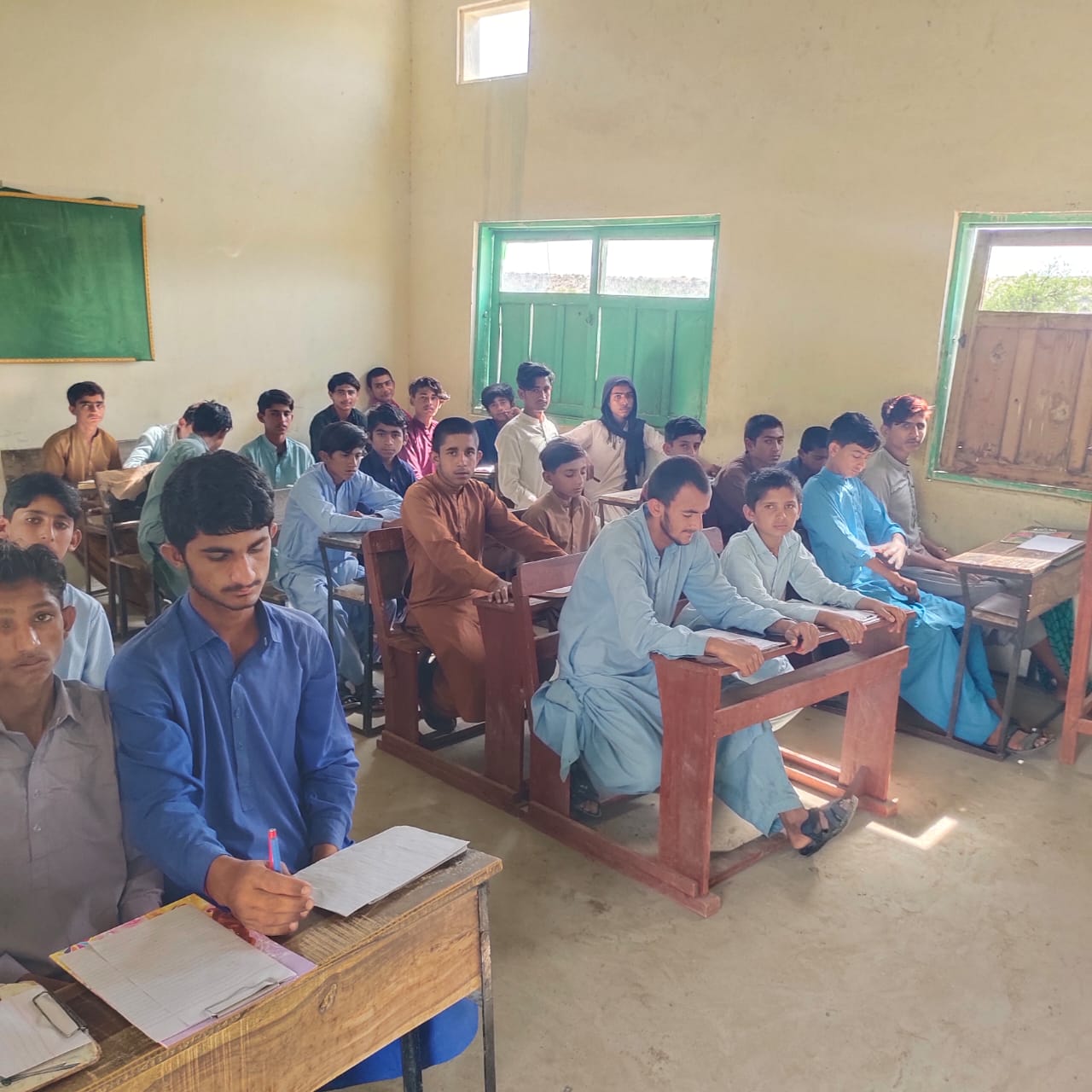 Students seated at wooden desks during a lesson