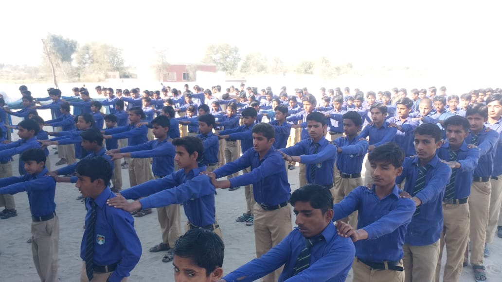 Rows of students in blue uniforms at morning assembly drill