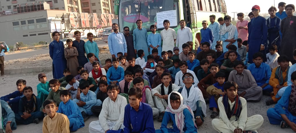 Students and teachers ready for a school trip beside the bus